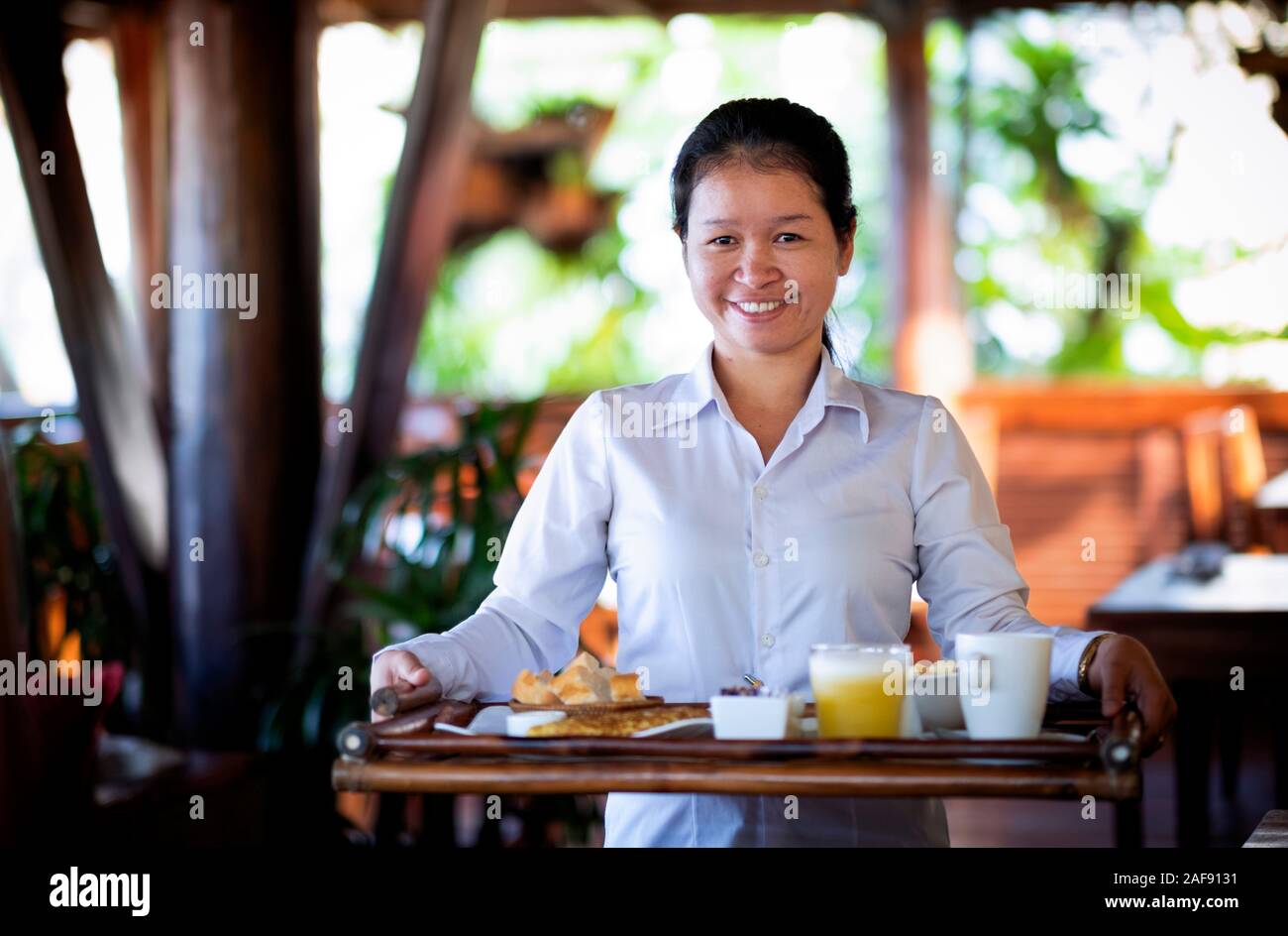Cambogia. Una cameriera che porta un vassoio Foto Stock