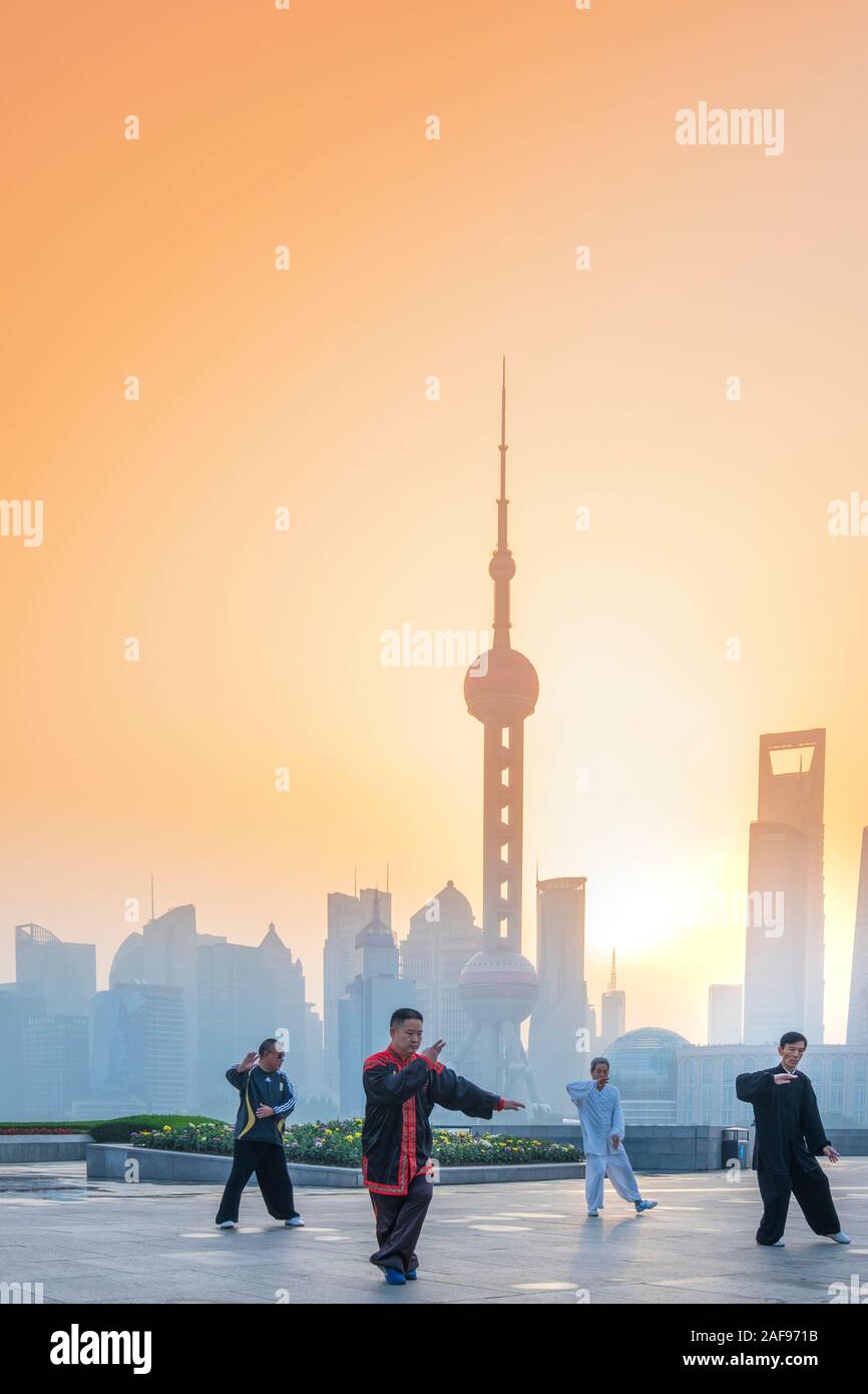 La gente del posto facendo Tai Chi all'alba contro il Pudong e la skyline di Shanghai, Cina Foto Stock
