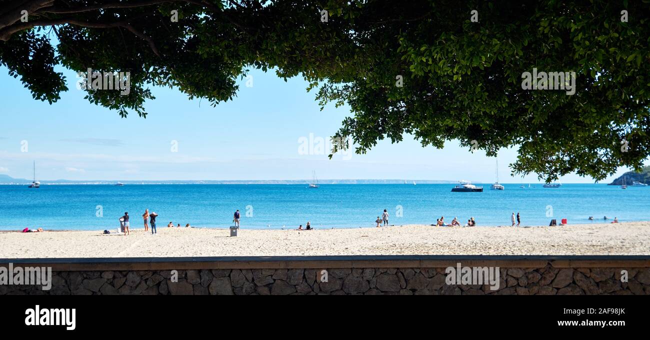 I turisti si godono il clima caldo sulla spiaggia di sabbia di Palma Nova luogo bello, colori luminosi. Spagnolo Baleari isola di Maiorca, Spagna Foto Stock