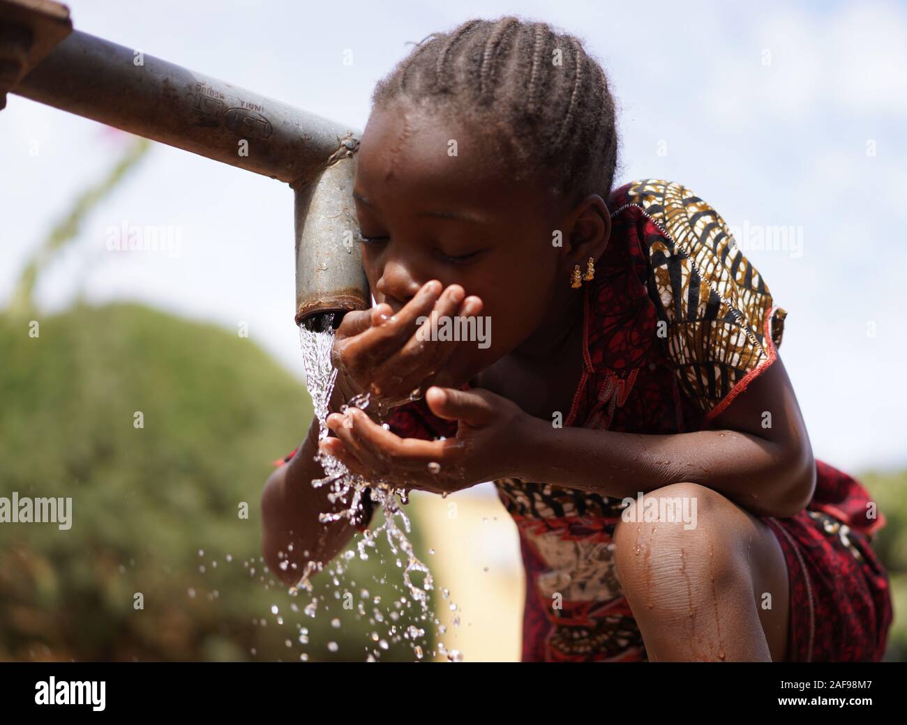 Simbolo Del Cambiamento Climatico, Cute African Little Woman With Water Foto Stock