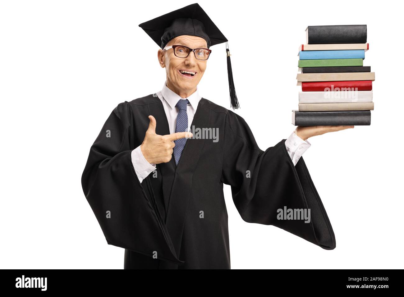 Senior uomo che indossa un abito di graduazione e titolari di una pila di libri isolati su sfondo bianco Foto Stock