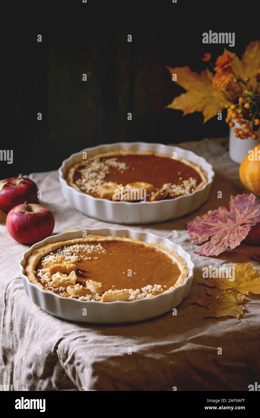 In casa tradizionale autunno torte di zucca per il giorno del Ringraziamento o di Halloween cena servita nel piatto di ceramica con giallo Foglie di autunno, zucche e mele su Foto Stock