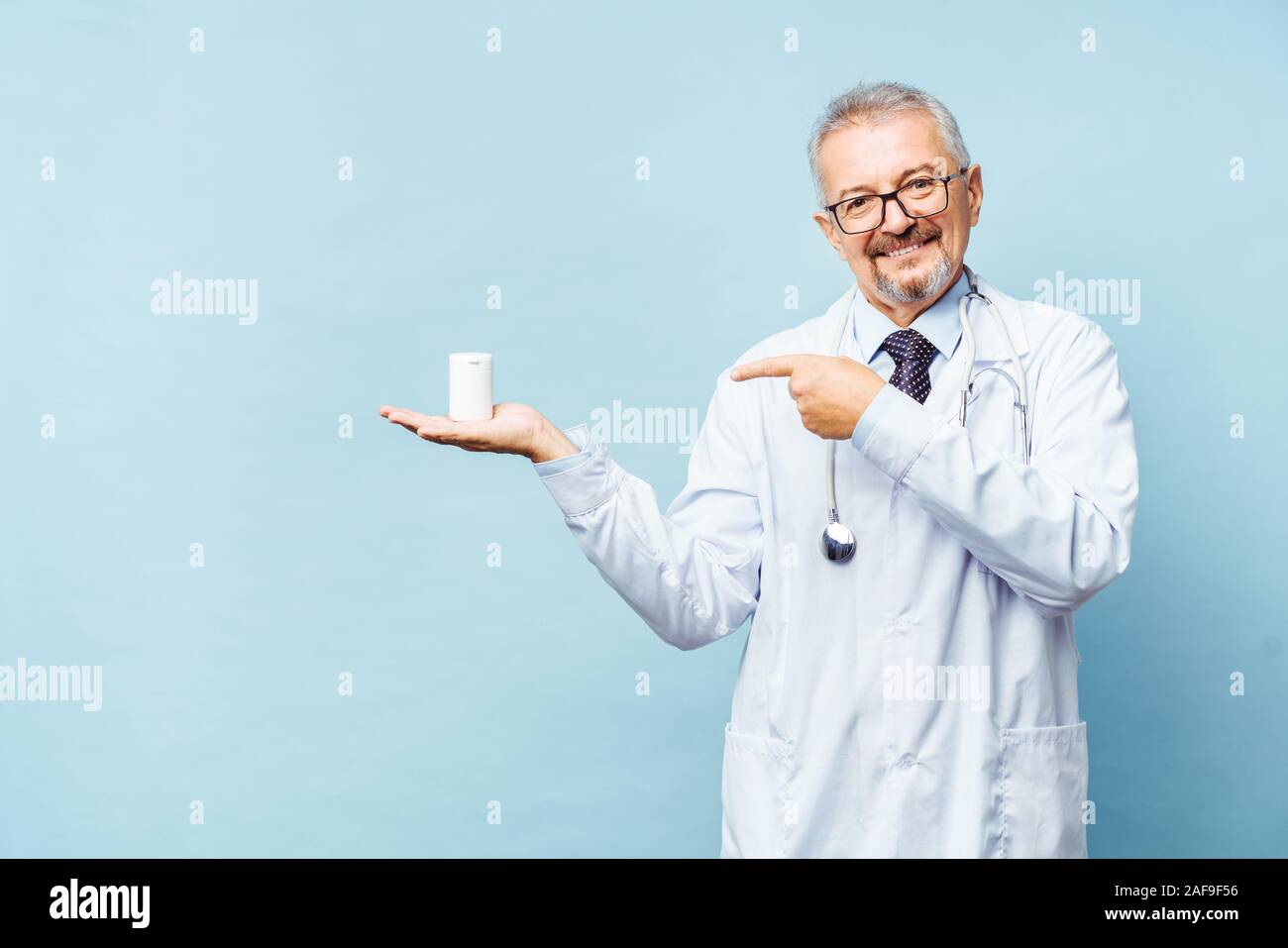 Medico tenendo una bottiglia di pillole su sfondo bianco. Il concetto di medicina, farmacologia, healthcare Foto Stock