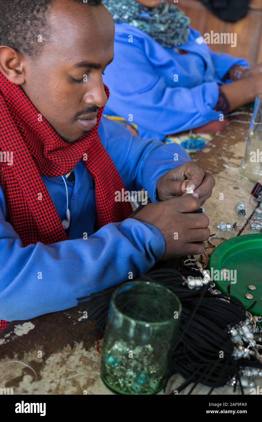 Arusha, Tanzania. L'uomo posizionare i talloni su Hairpieces a Shanga, un centro artigianale che impiega i portatori di handicap. Foto Stock