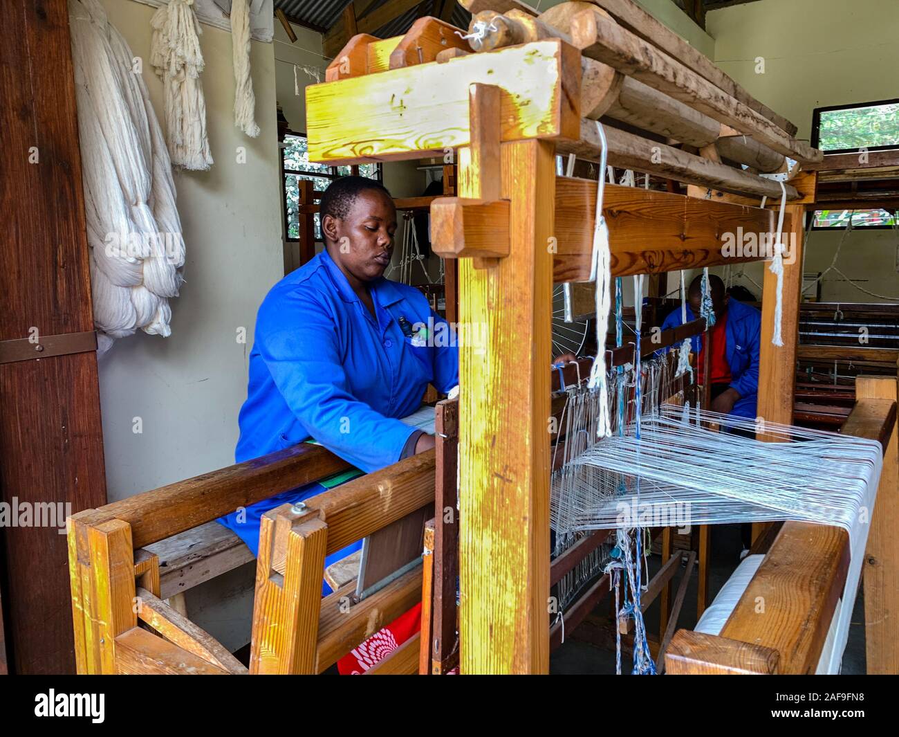Arusha, Tanzania. La donna lavora al suo telaio a Shanga, un centro artigianale che impiega i portatori di handicap. Foto Stock