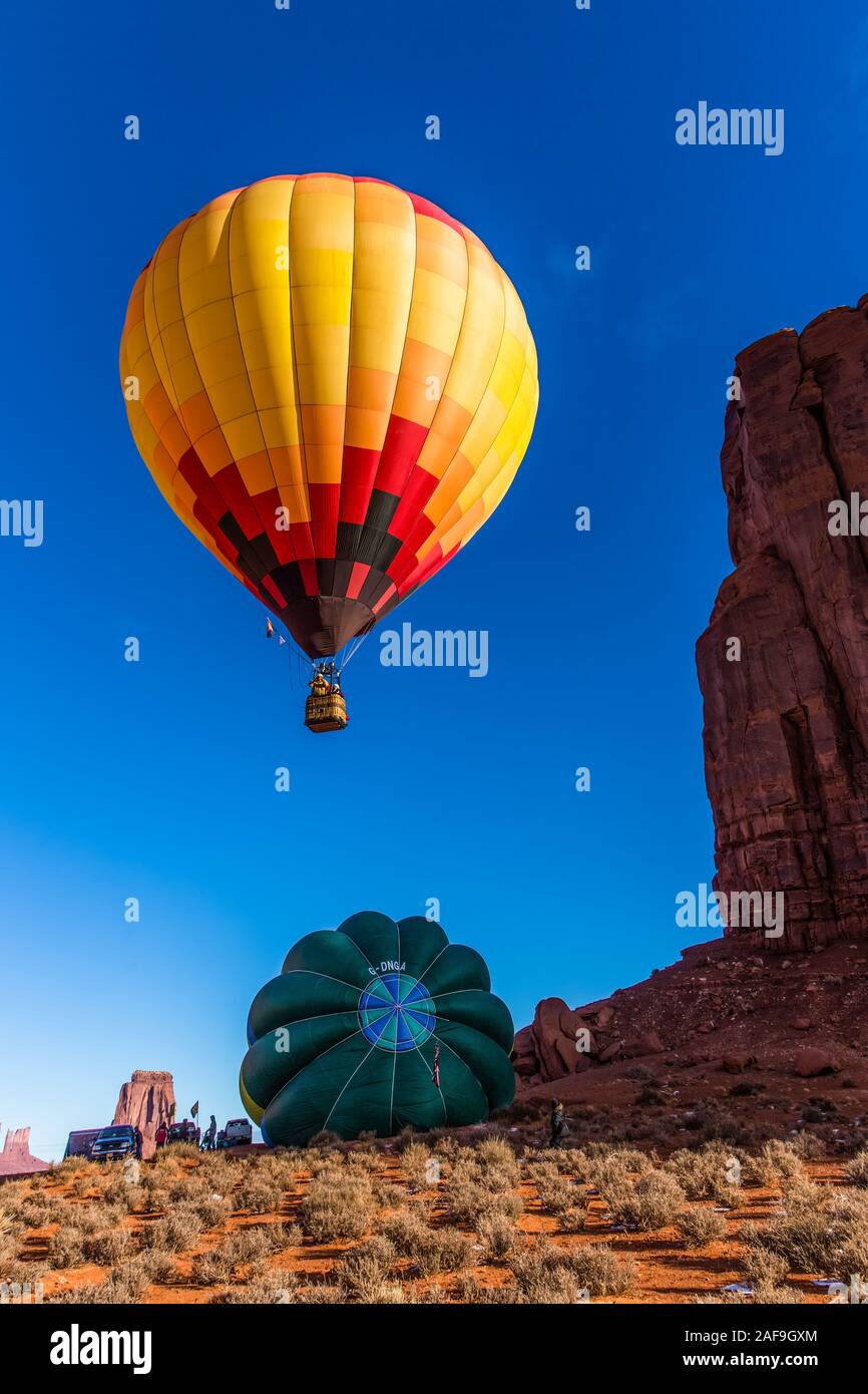 Una mongolfiera sorge nelle prime ore del mattino cielo in Monument Valley Balloon Festival nel parco tribale Navajo Monument Valley in Arizona. Anothe Foto Stock