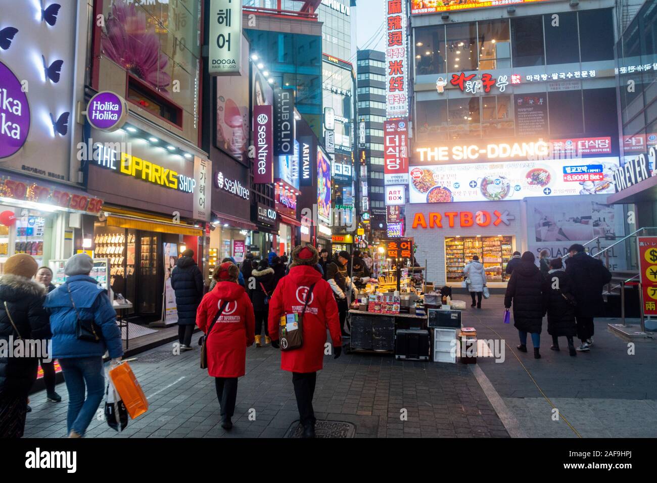 Seoul, Corea del Sud - 6 Dicembre 2019: a Myeongdong district a sera, il popolare sito per trattamenti estetici e di bellezza e negozi di cibo di strada. Foto Stock