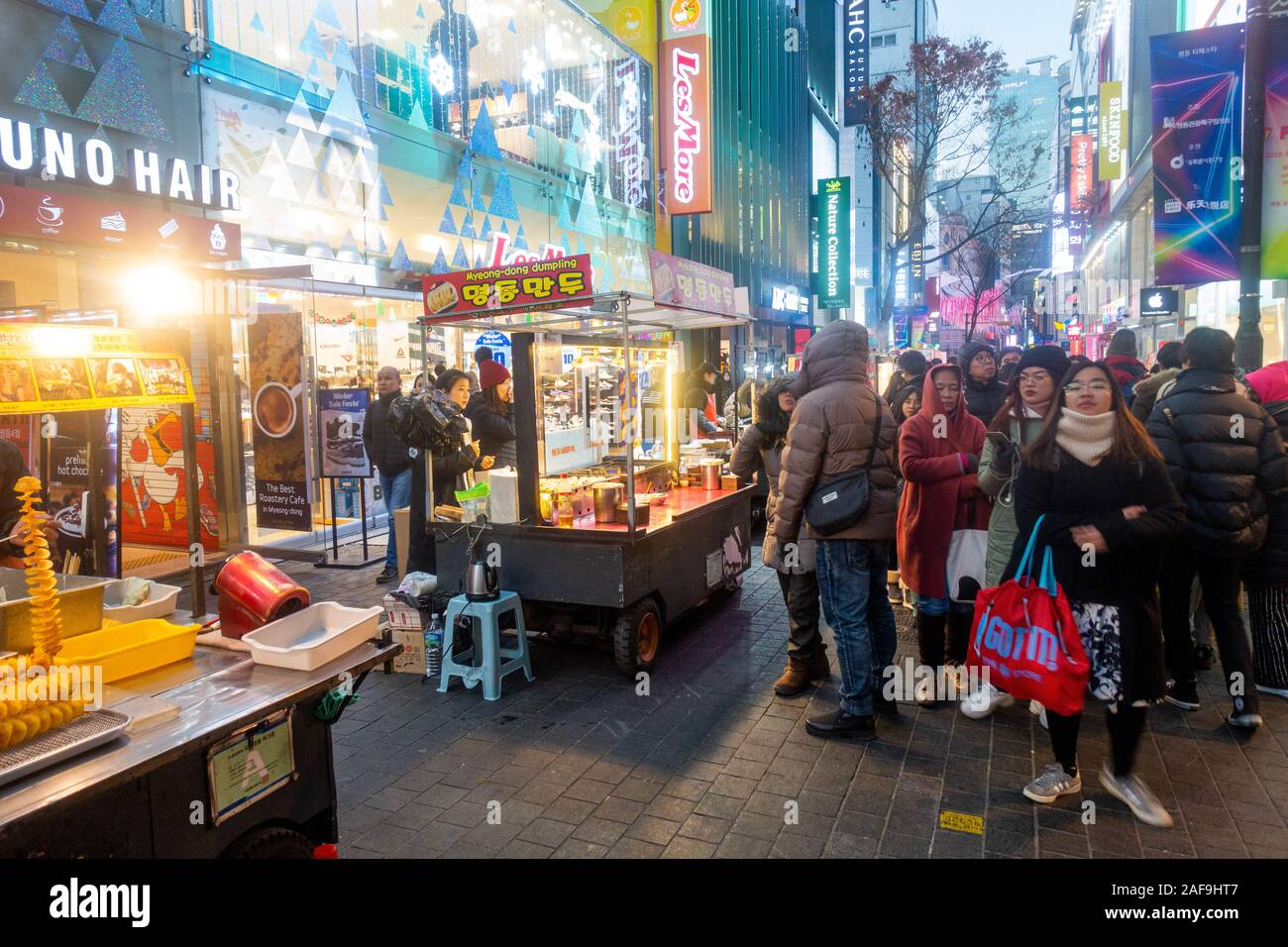 Seoul, Corea del Sud - 6 Dicembre 2019: a Myeongdong district a sera, il popolare sito per trattamenti estetici e di bellezza e negozi di cibo di strada. Foto Stock