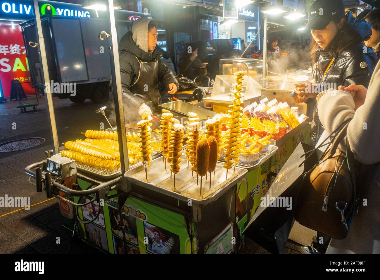 Seoul, Corea del Sud - 6 Dicembre 2019: a Myeongdong district a sera, il popolare sito per trattamenti estetici e di bellezza e negozi di cibo di strada. Foto Stock