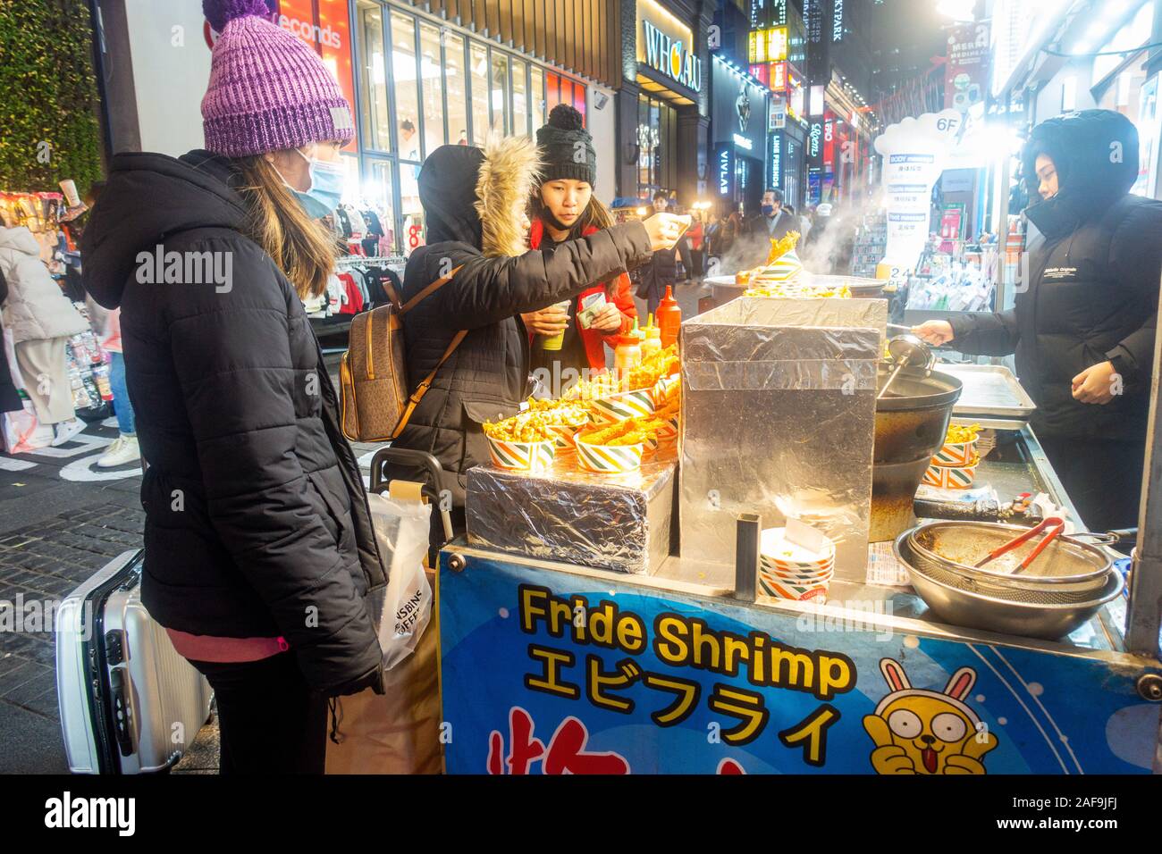 Seoul, Corea del Sud - 6 Dicembre 2019: a Myeongdong district a sera, il popolare sito per trattamenti estetici e di bellezza e negozi di cibo di strada. Foto Stock