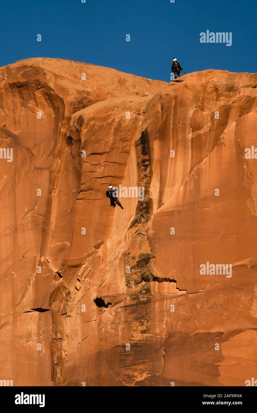 Un ponticello di base salta fuori il piede 400 faccia verticale dell'oggetto contrassegnato per la rimozione definitiva in Kane molle Canyon vicino a Moab, Utah. Foto Stock