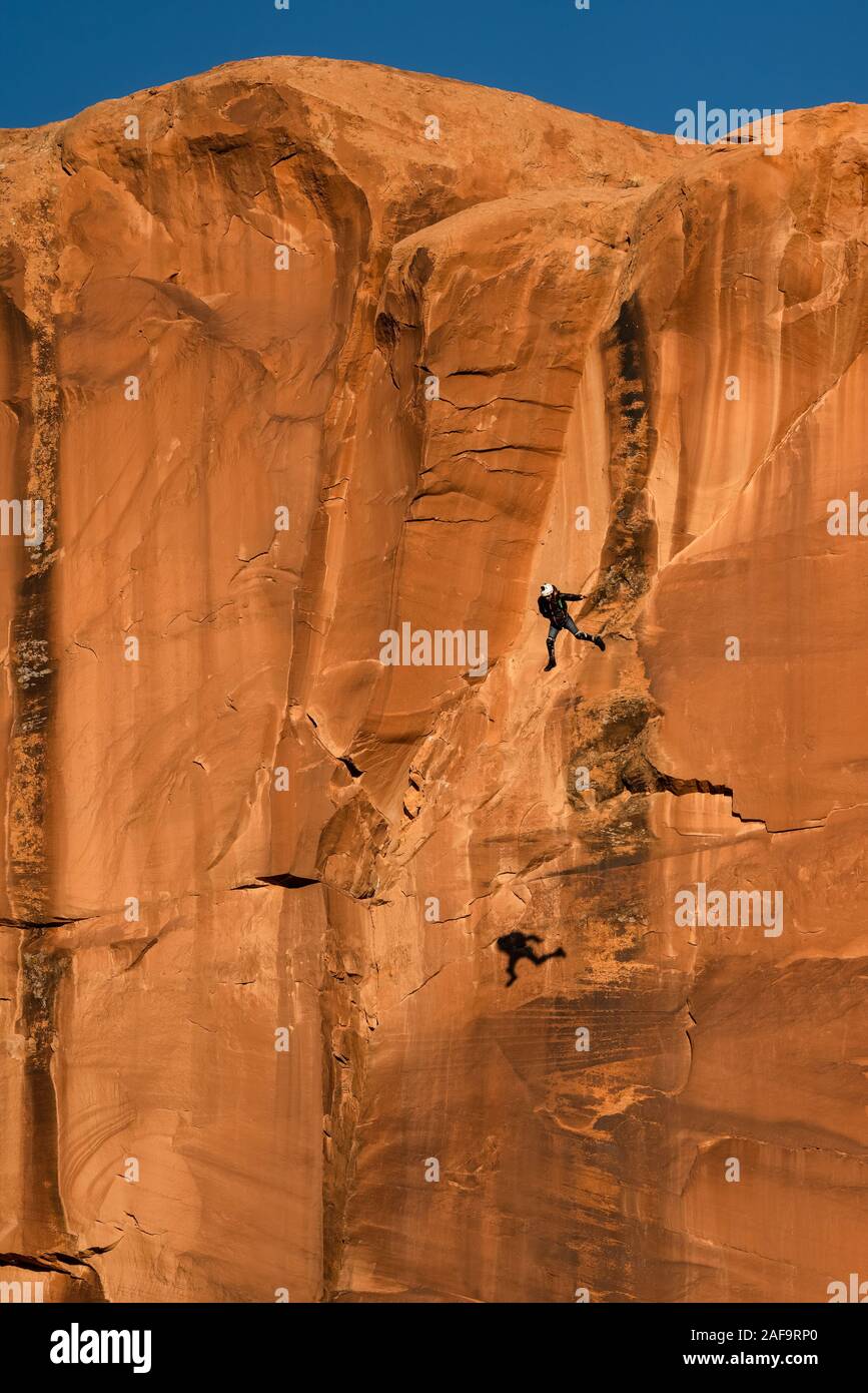 Un ponticello di base in caduta libera off 400 piedi faccia verticale dell'oggetto contrassegnato per la rimozione definitiva prima del suo principale paracadute si apre in Kane molle Canyon vicino a Moab, Utah. N. Foto Stock