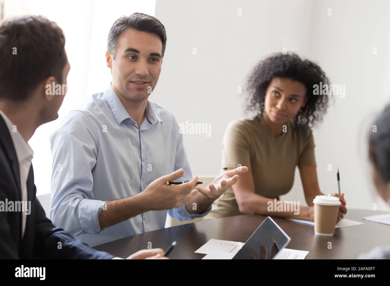Imprenditore fiducioso per condividere pensieri con i colleghi al mattino briefing Foto Stock