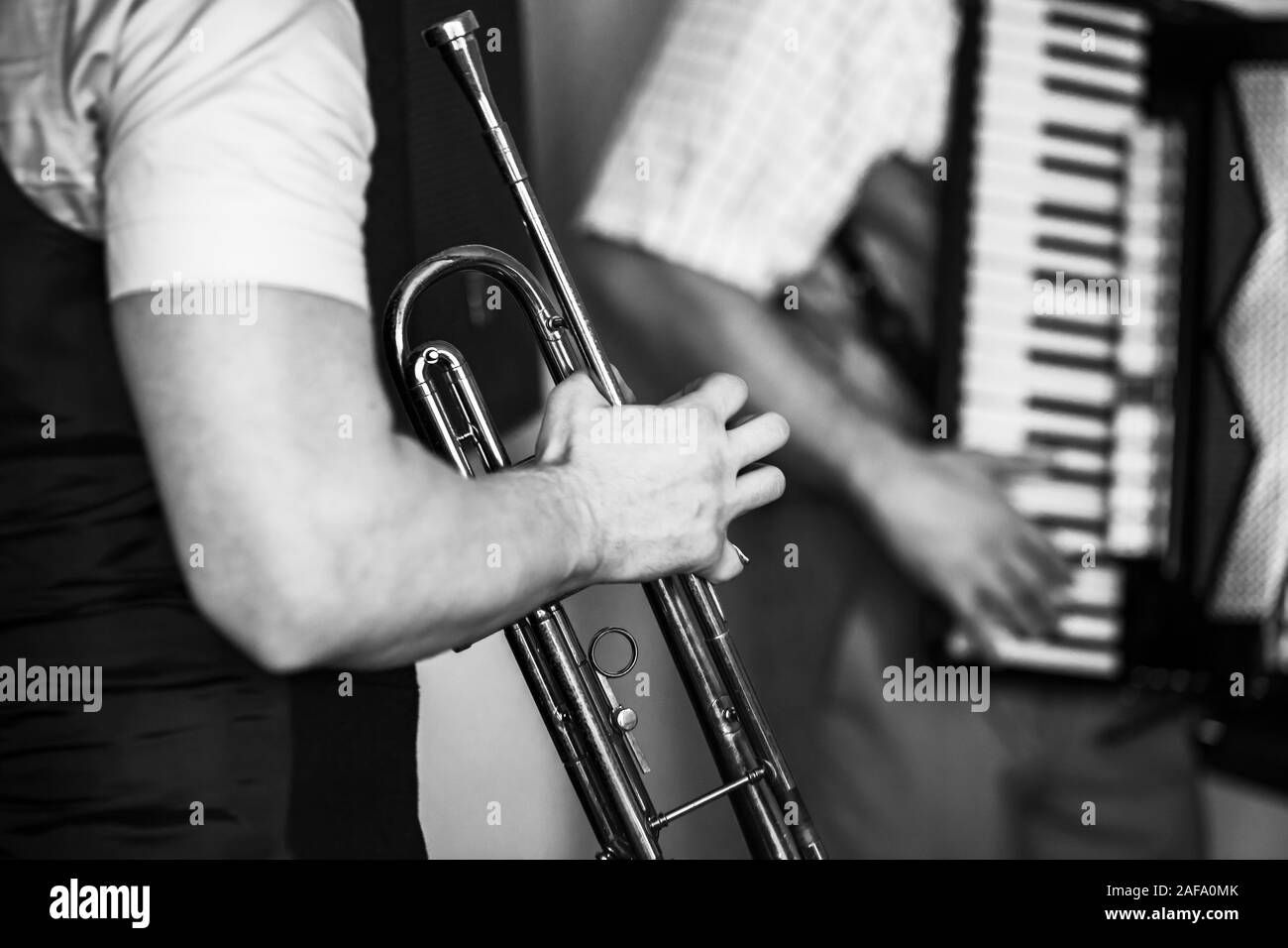 La tromba nelle mani di un musicista. Retrò stilizzata foto in bianco e nero, live musica di sottofondo Foto Stock