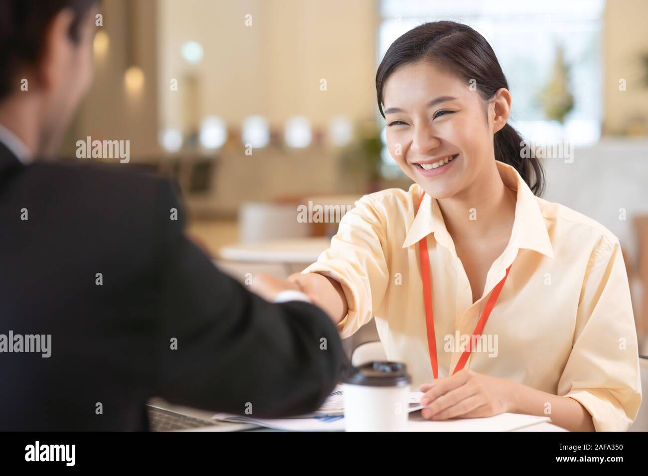 Ritratto di giovane donna asiatica intervistatore e intervistato stringono le mani per un colloquio di lavoro .Business handshake persone in ufficio moderno. Saluto trattare co Foto Stock