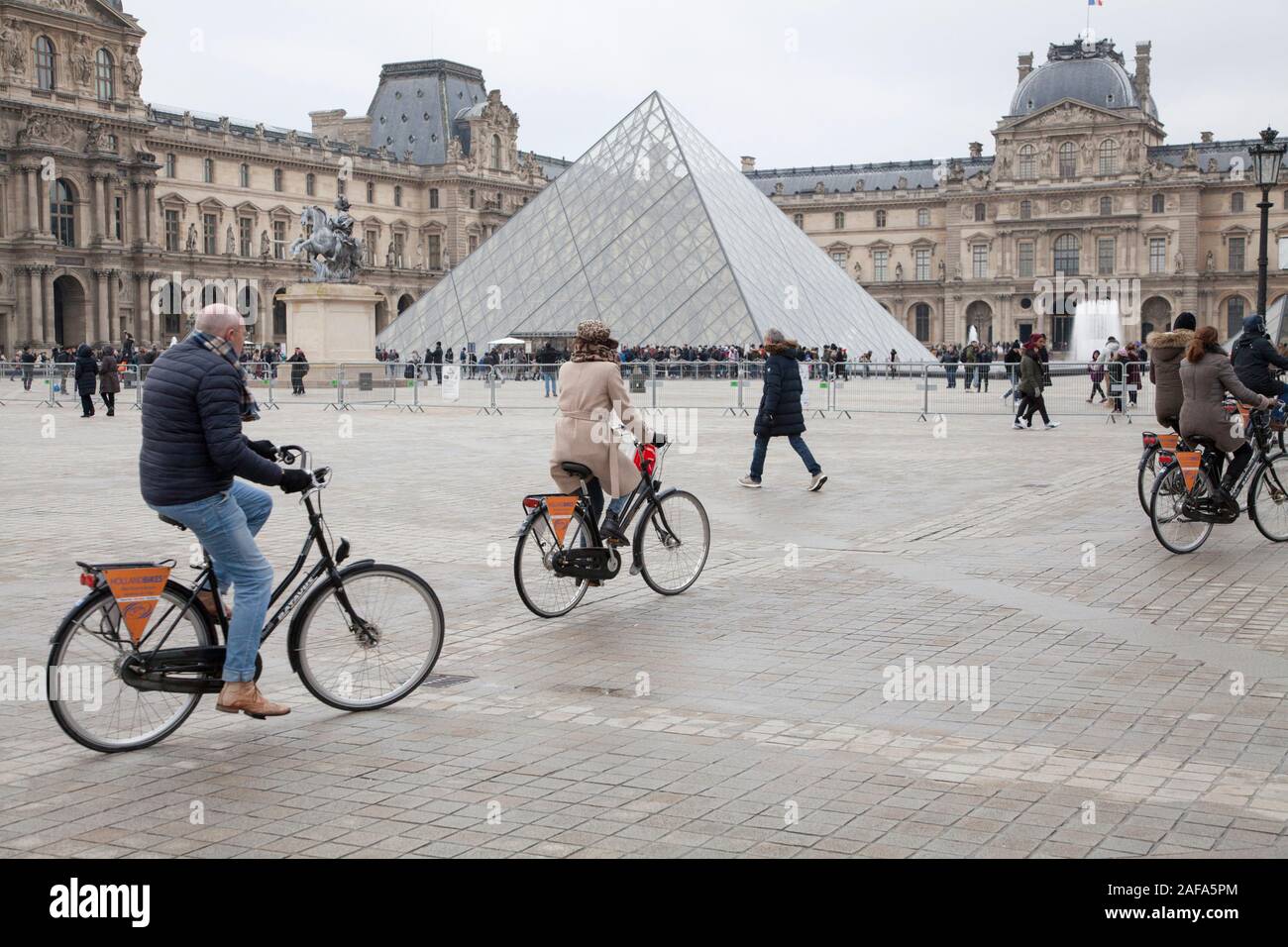 Un ciclo tour arriva al museo del Louvre a Parigi in una tranquilla mattinata d'inverno Foto Stock