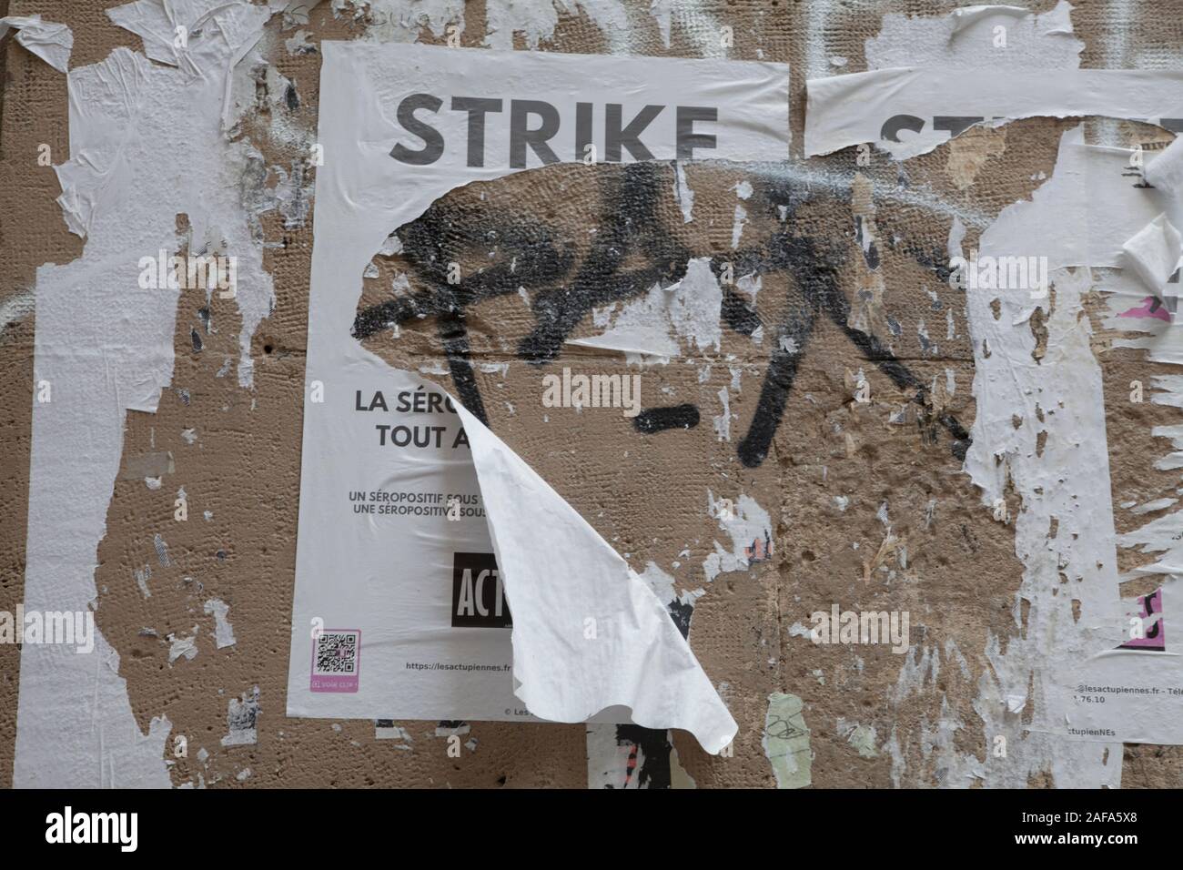 Un poster strappato sollecitando STRIKE incollata su una parete mentre è in corso una serie di proteste e scioperi in Francia Foto Stock