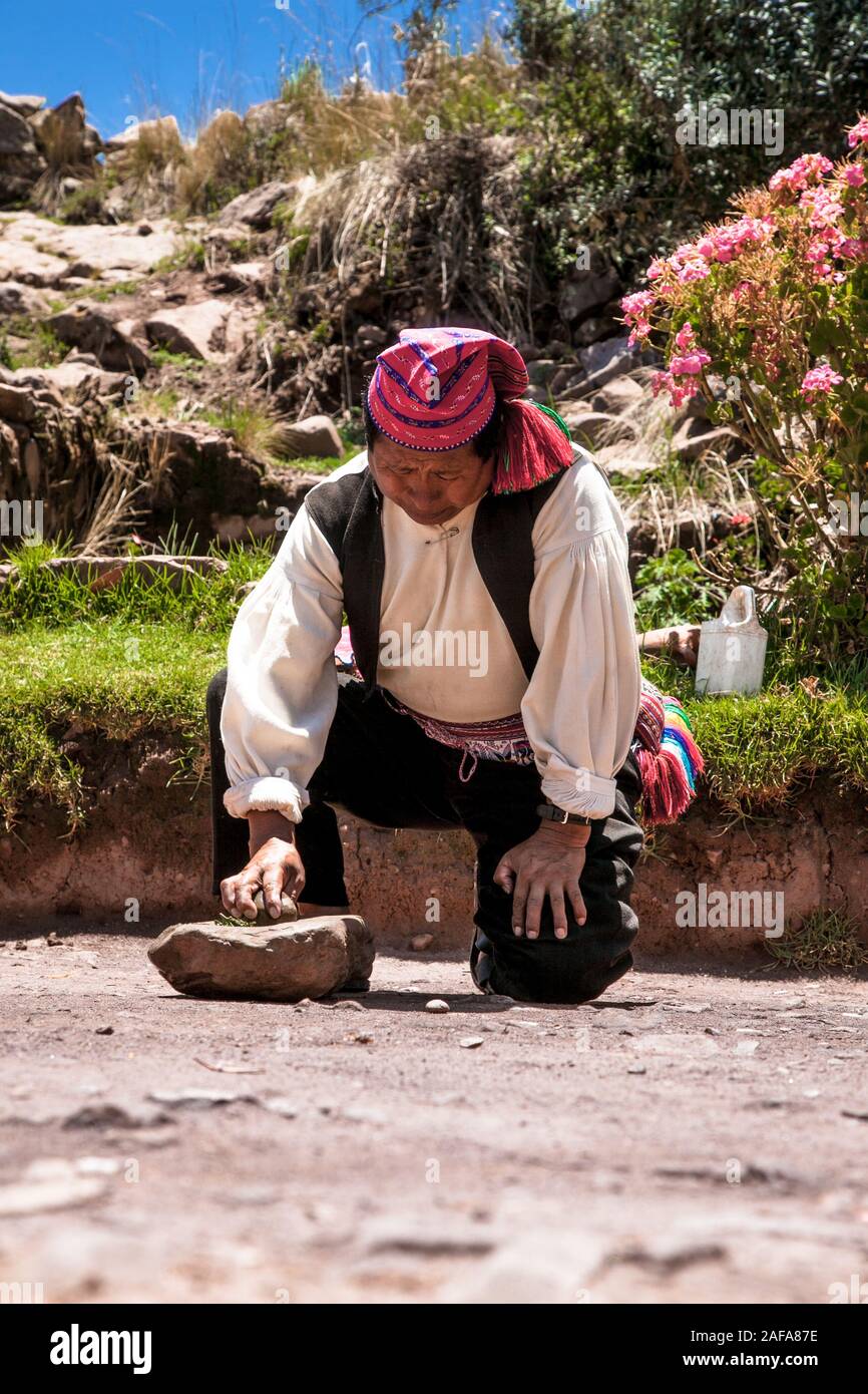Taquile, Perù - Jan 5, 2019 :l uomo in abiti tradizionali rende lo shampoo a Taquile isola del lago Titicaca in Perù. Foto Stock