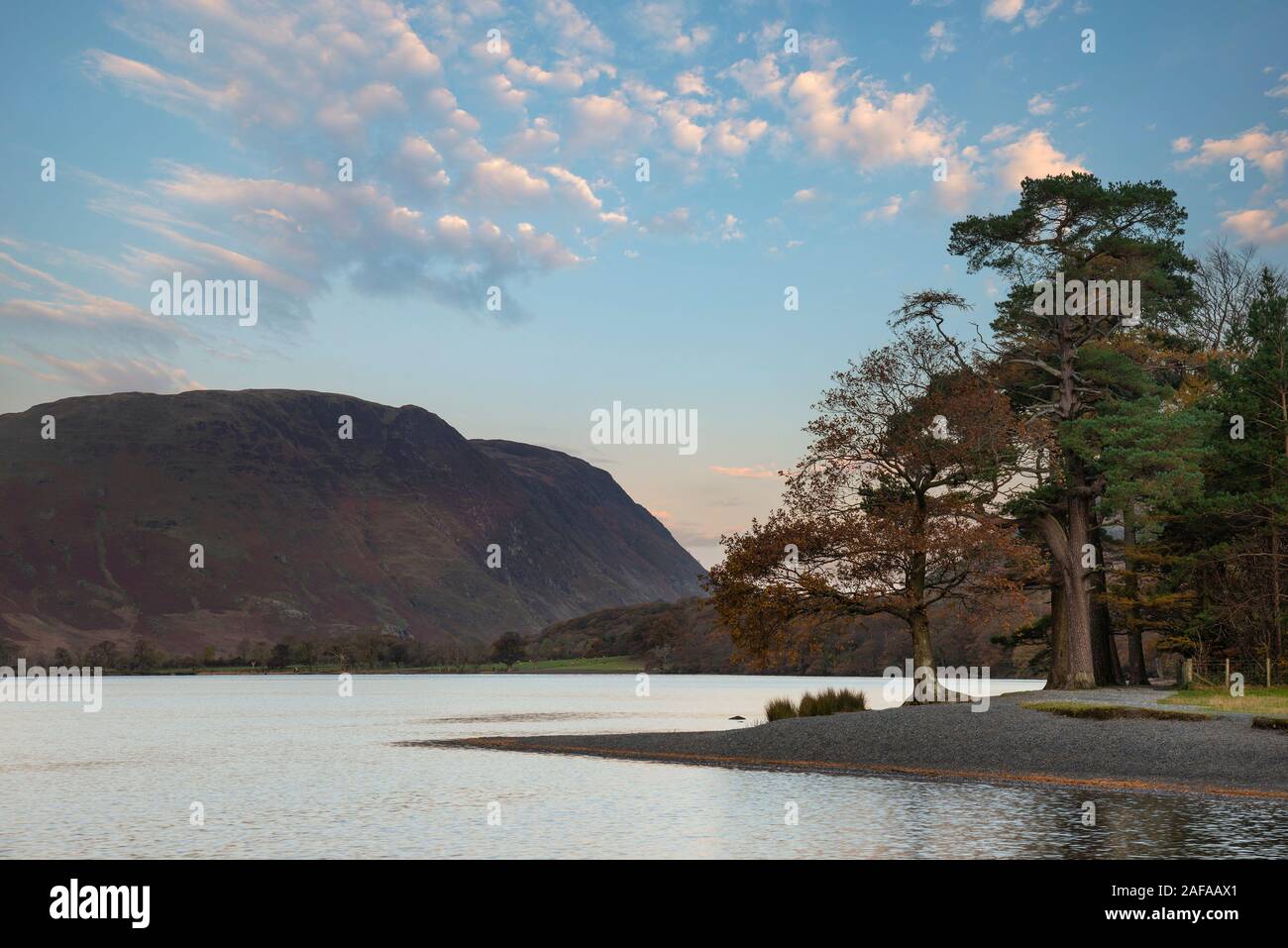 Incredibile epic Autumn Fall paesaggio Buttermere nel Lake District con una bella mattina presto la luce del sole giocando attraverso le colline e le montagne Foto Stock