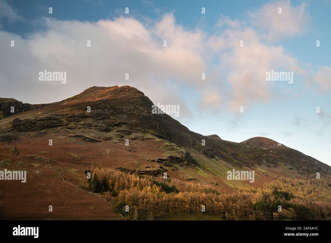 Incredibile epic Autumn Fall paesaggio Buttermere nel Lake District con una bella mattina presto la luce del sole giocando attraverso le colline e le montagne Foto Stock