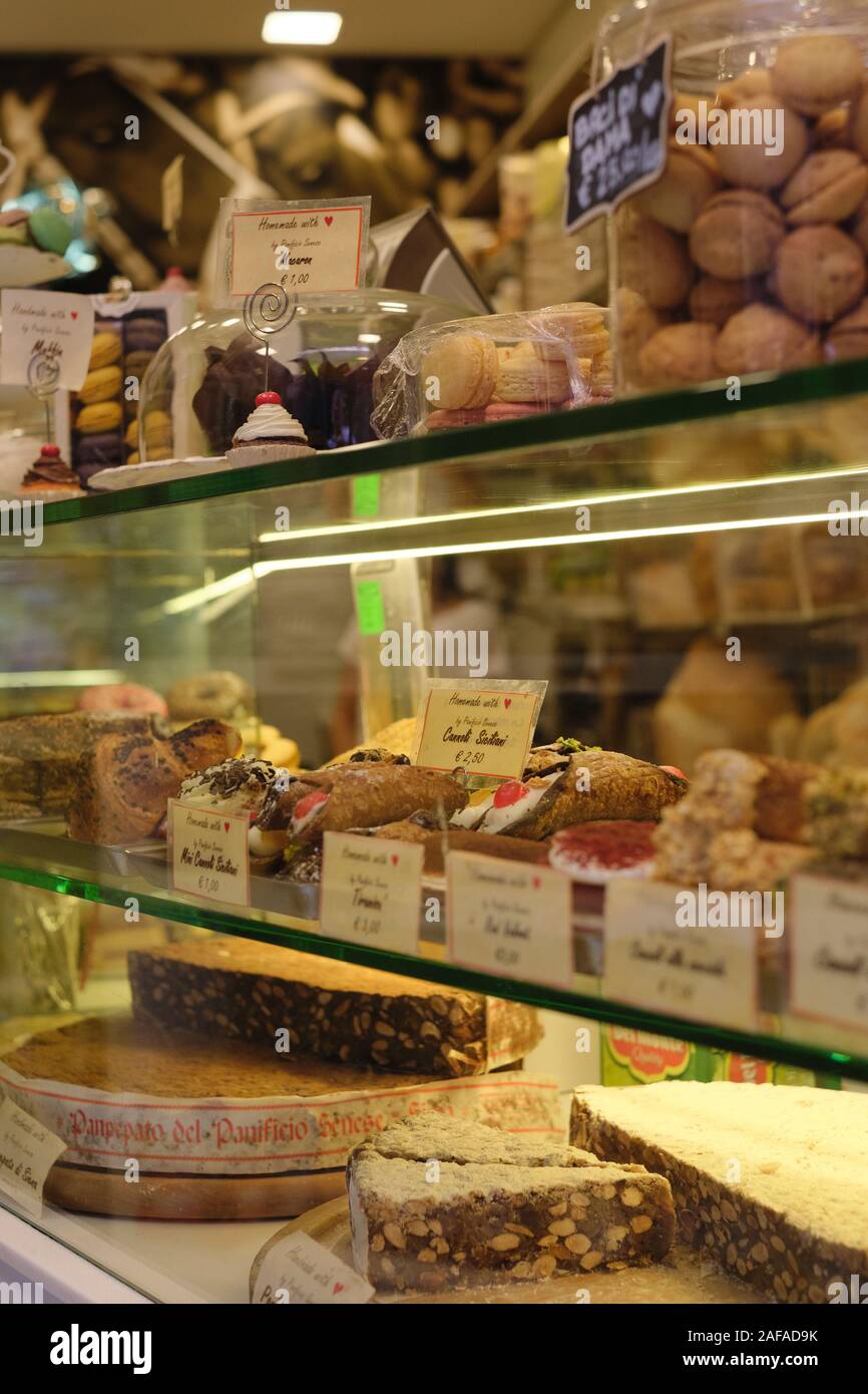 Il display del contatore di torte e i dolci e la pasticceria in un piccolo negozio di specialità gastronomiche cake shop in Siena Toscana Italia EU - Italia Pasticceria Foto Stock