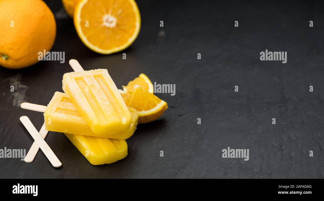 Orange Popsicles (messa a fuoco selettiva; close-up shot) su un sfondo vintage Foto Stock