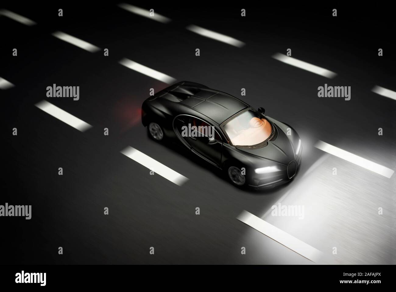 Izmir, Turchia - 28 luglio 2019. Vista dall'alto di un colore nero Bugatti Veyron giocattolo auto andando su una strada asfaltata con luci. Foto Stock