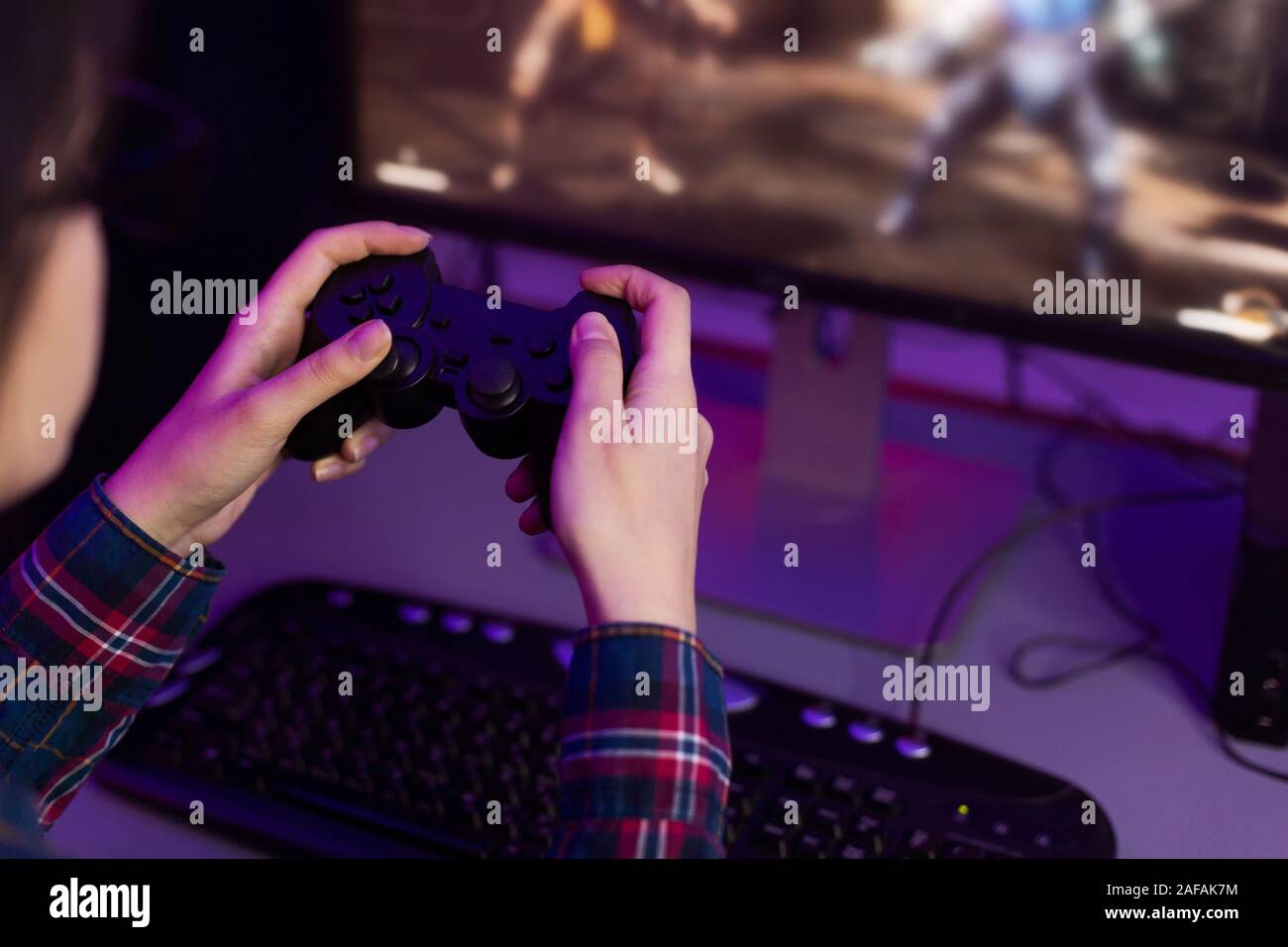 I videogamer femmina tenendo premuto il joystick e la riproduzione di video gioco Foto Stock