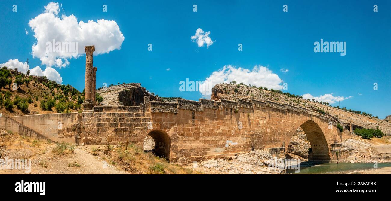 Vista panoramica del Ponte Severan, Cendere Koprusu è un fine ponte romano, vicino a Nemrut Dagi, Turchia. Strada fiancheggiata da colonne antiche Foto Stock