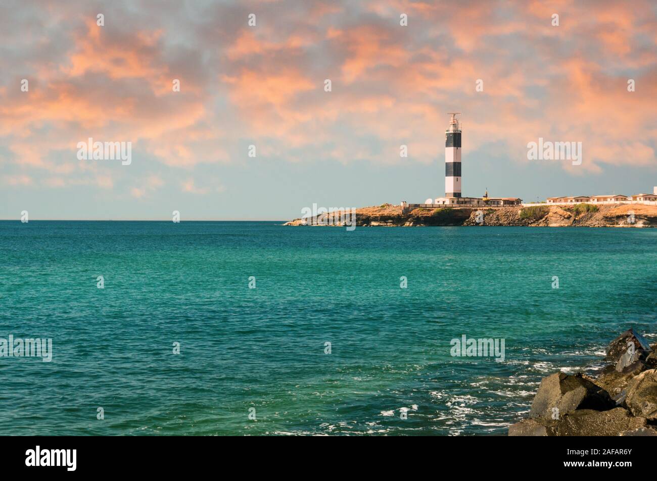 Faro e demolitori di onda sulla costa del bel blu mare Arabico Foto Stock