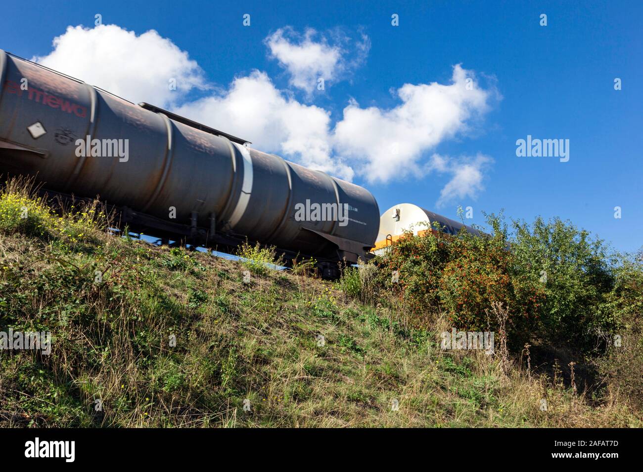 I carri cisterna su un terrapieno ferroviario Foto Stock