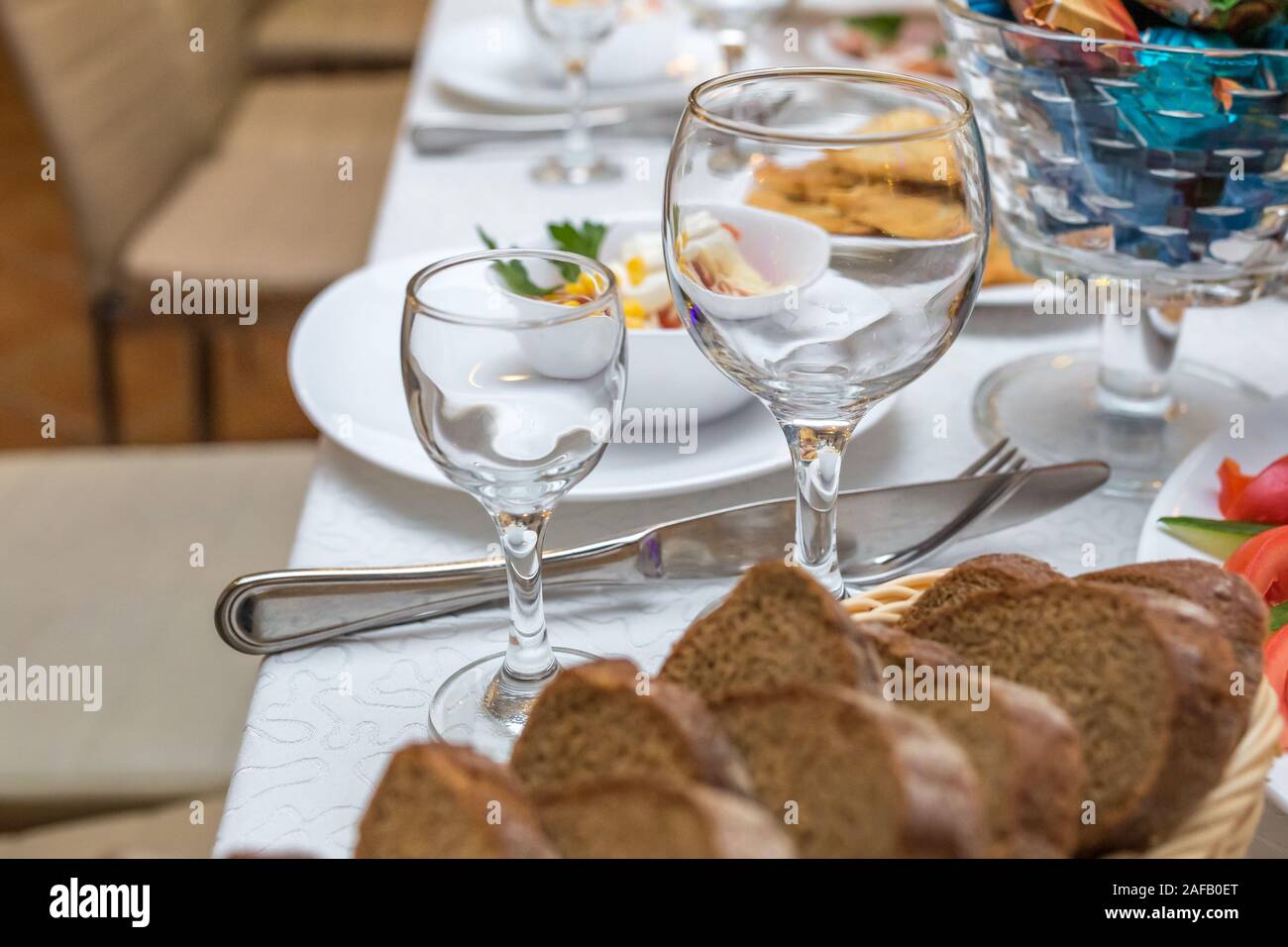Tavola da banchetto servito con strumenti e decorate con vuoto bicchieri di vino Foto Stock