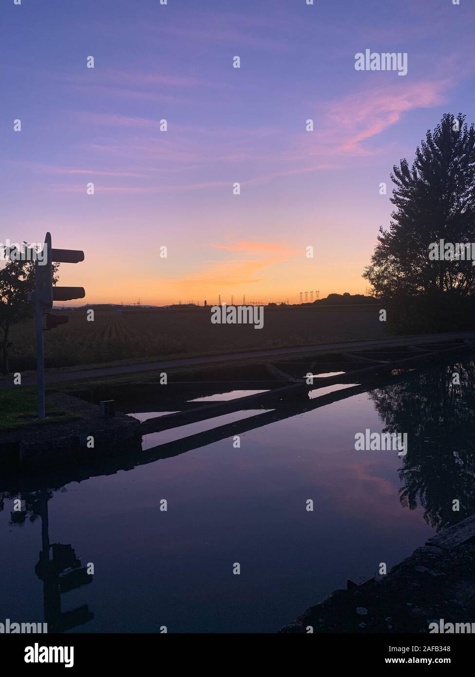 Bellissimo tramonto sul fiume Reno canal a Strasburgo Souffelweyersheim con i pali dell'elettricità da energia locale provider Foto Stock