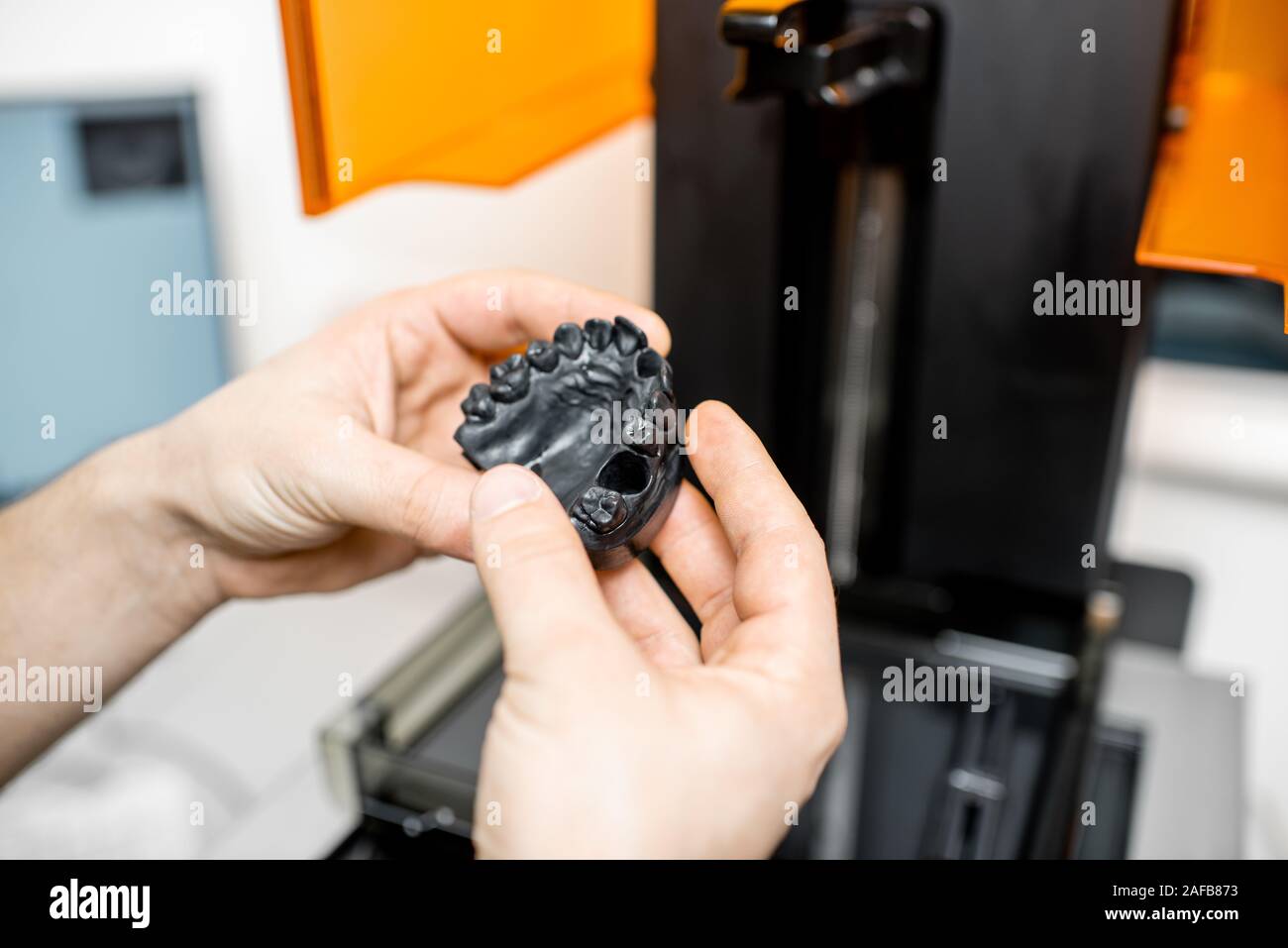 Odontotecnico rimozione modello ganascia da una stampante 3D presso il laboratorio, modellazione telaio per la produzione di impianto Foto Stock