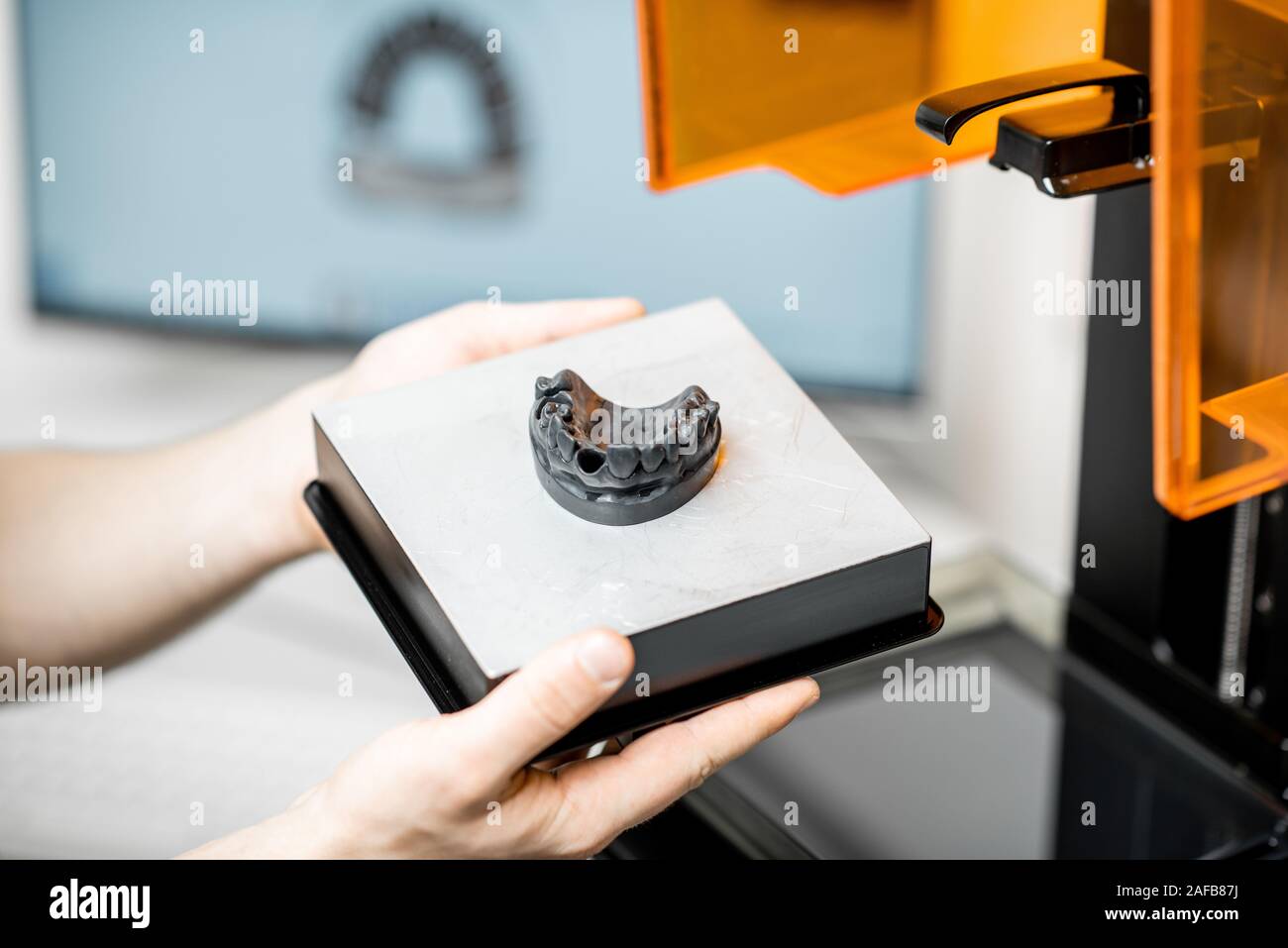 Odontotecnico rimozione modello ganascia da una stampante 3D presso il laboratorio, modellazione telaio per la produzione di impianto Foto Stock
