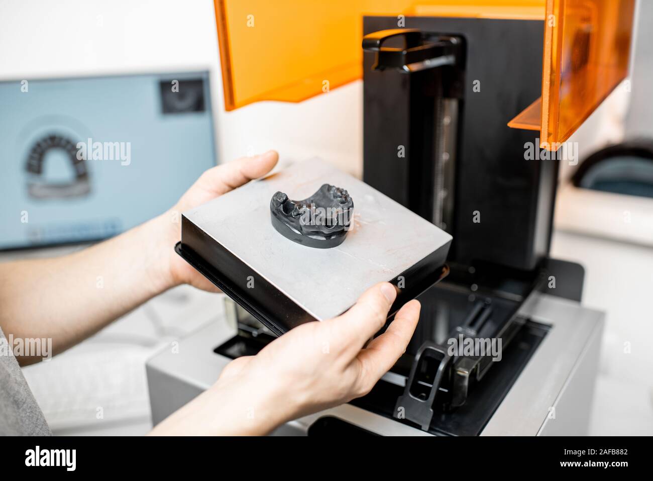 Odontotecnico rimozione modello ganascia da una stampante 3D presso il laboratorio, modellazione telaio per la produzione di impianto Foto Stock