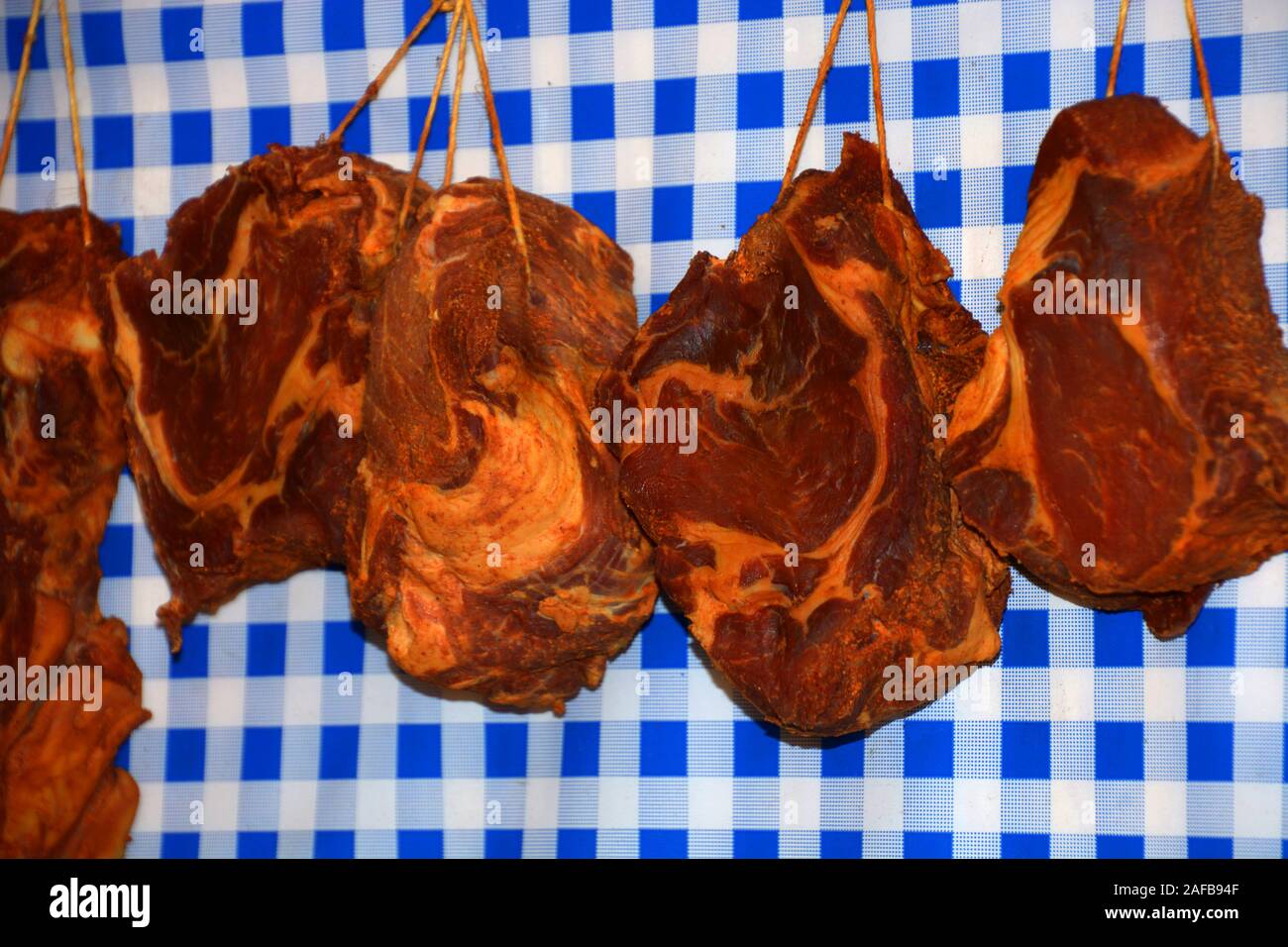 Carne affumicata nella parte anteriore dei bianco-blu di stile bavarese sfondo, delicatezza tedesco affumicato di carne di maiale Foto Stock