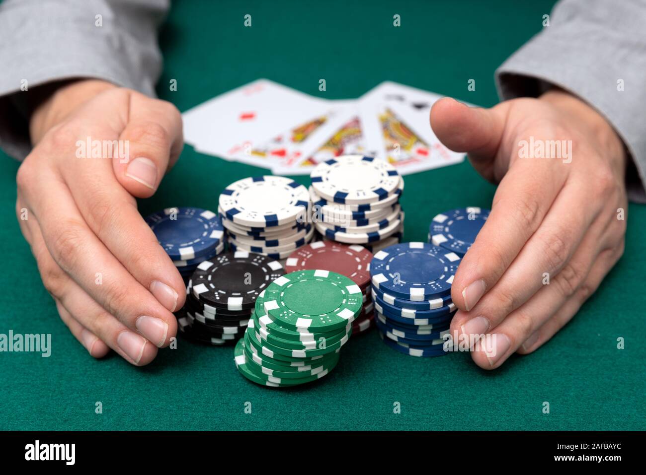 L'uomo gioca a poker al casinò. L uomo lo stack di raccolta del poker chips, concetto di gioco d'azzardo. Foto Stock