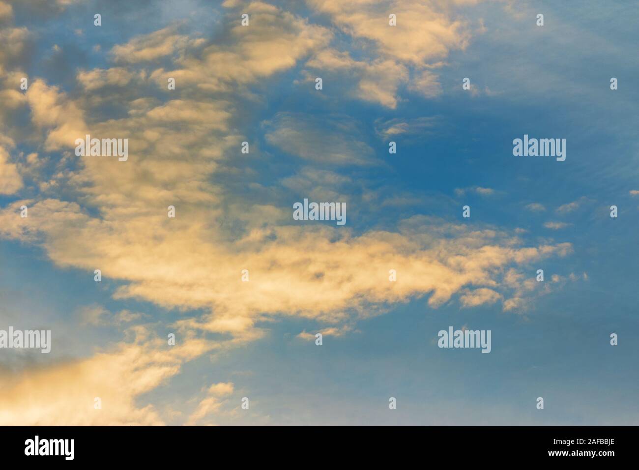 Nuvole d'oro su un cielo blu al tramonto. bellissima natura sfondo. Atmosfera meravigliosa scenografia di sera. nuvoloso meteo in serata concep Foto Stock