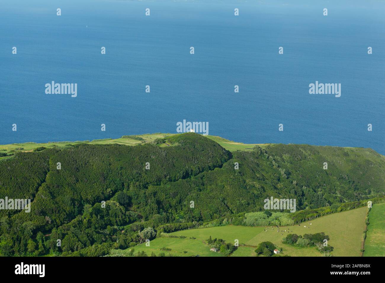 Le azzurre acque dell'Oceano Atlantico a contrasto con i verdi campi dell'isola di Faial Foto Stock