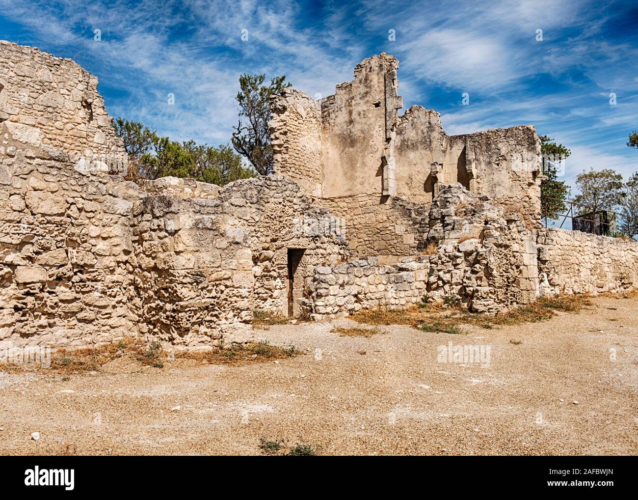 Sbriciolare i muri in pietra circondano le rovine della vecchia fortezza a Baux-de-Provence in Francia. Foto Stock
