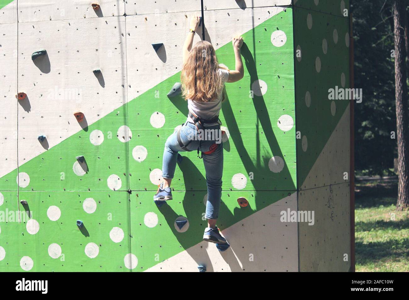Ragazza in un libero parete di arrampicata nel parco. Sport Foto Stock