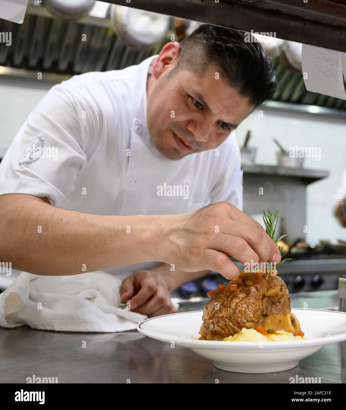 Ristorante Iguana Executive Chef Gesù Suastegui mettendo tocco finale su un Chamorro de Puerco (lo stinco di maiale) entree a Casa Kimberly, Puerto Vallart Foto Stock