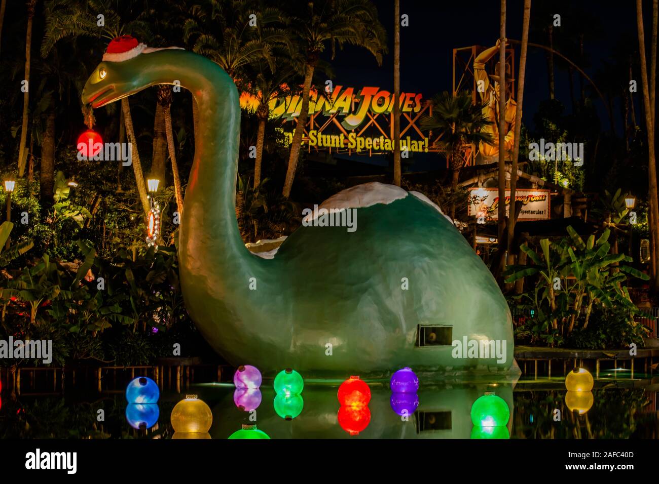 Orlando, Florida. Novembre 27, 2019. Grande dinosauro e decorazioni di Natale nel lago di eco agli Studios di Hollywood Foto Stock