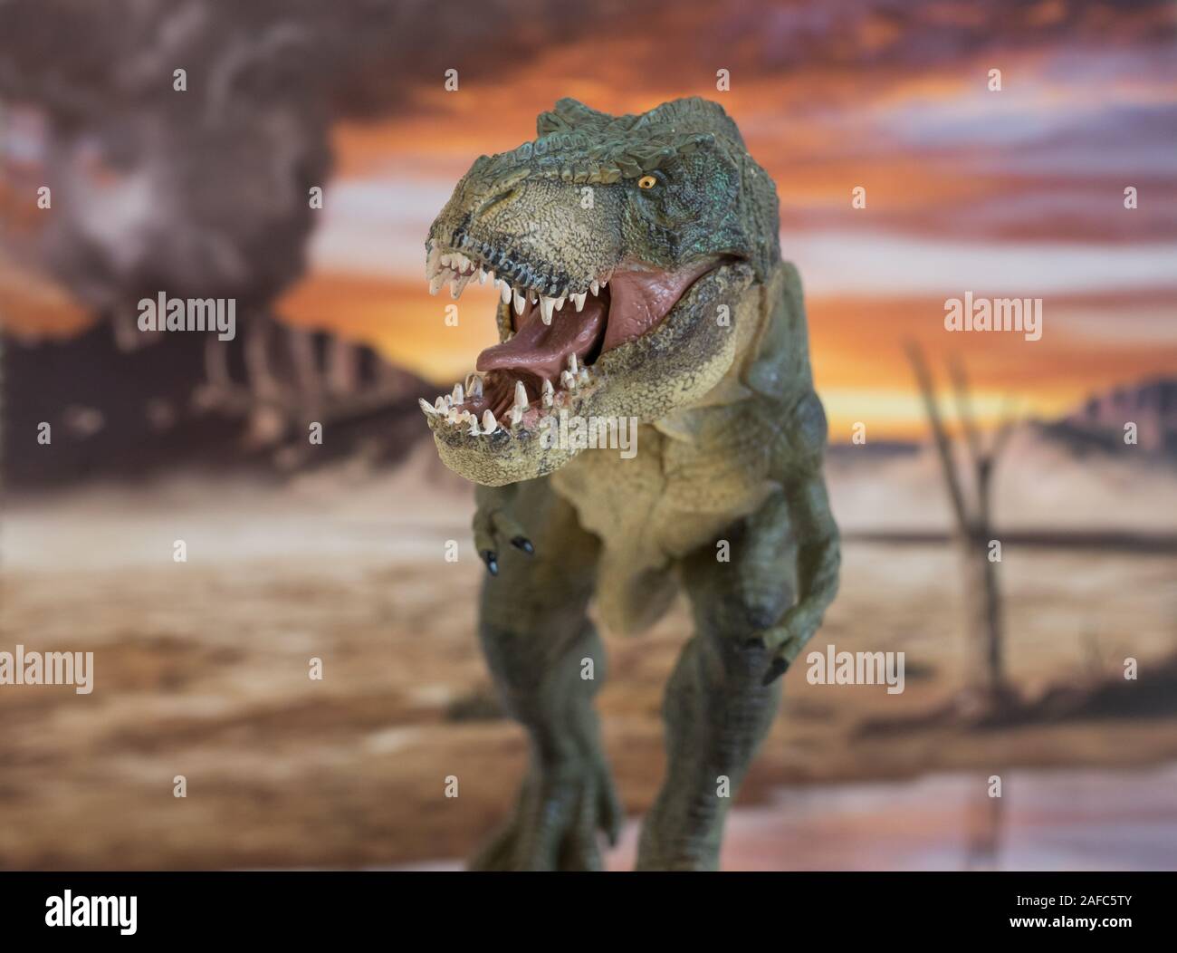 Ritratto di camminare e pericoloso Tyrannosaurus rex con il vulcano in eruzione in background. Vista frontale. Foto Stock