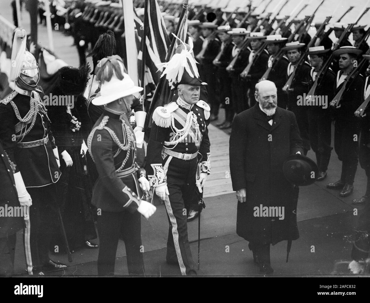 Il Primo Ministro dell'Australia Sir Joseph Cook e Governatore Generale di ispezionare una linea di marinai. Sir Joseph Cook (Primo Ministro), Sir Ronald Munro-Ferguson e altri dignitari a camminare lungo una linea di giovani velisti in paglia naviganti, fucili alle loro spalle Foto Stock