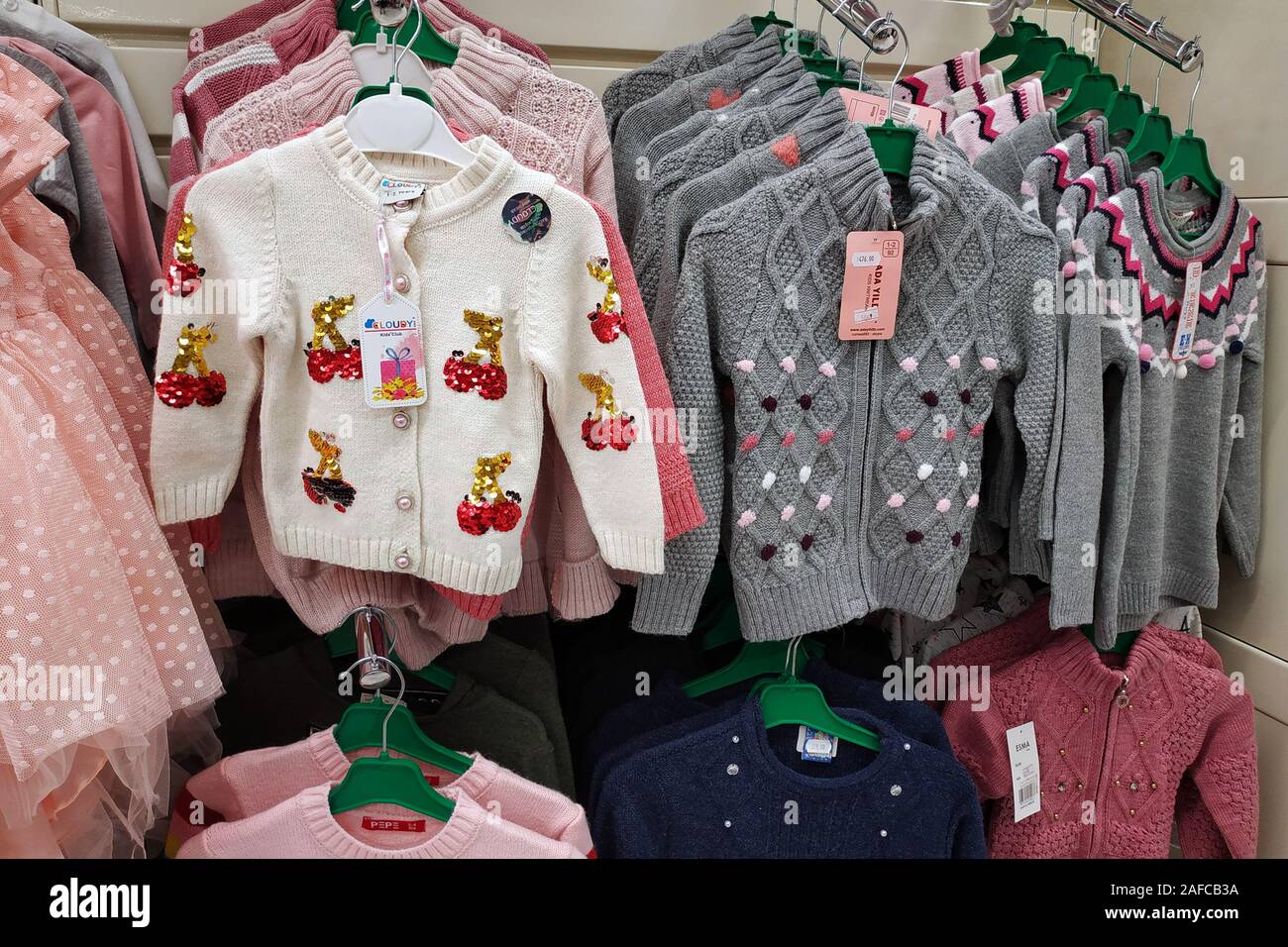 Abbigliamento per bambini nel negozio. Una nuova collezione di abiti alla  moda si blocca in una boutique. Luminose maglioni caldi con motivi, tema  natalizio Foto stock - Alamy