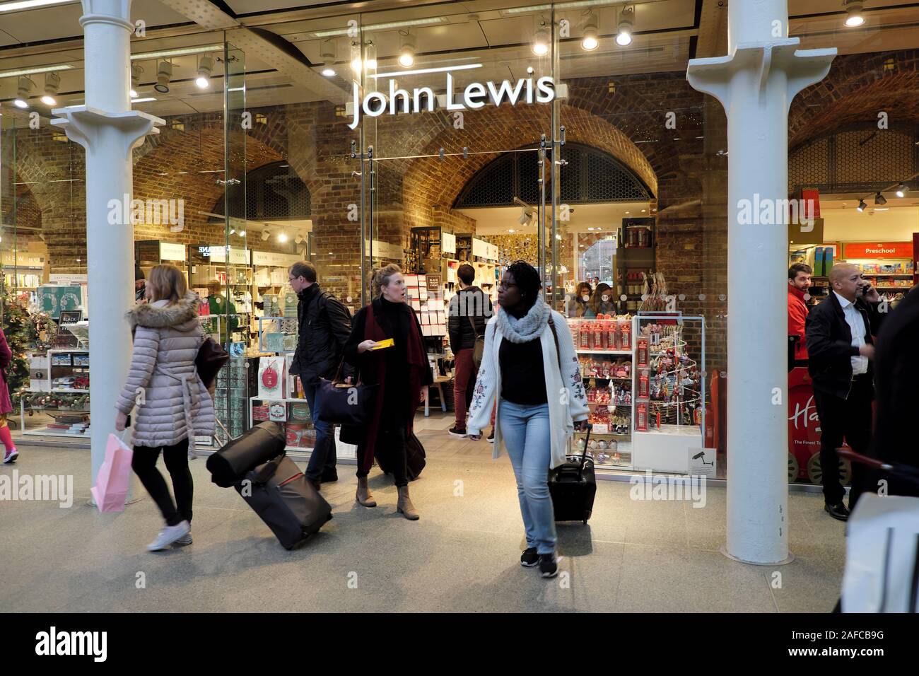 Persone con bagagli e acquirenti al di fuori dei negozi John Lewis presso il centro commerciale St Pancras Station Kings Cross a Londra Inghilterra Regno Unito KATHY DEWITT Foto Stock