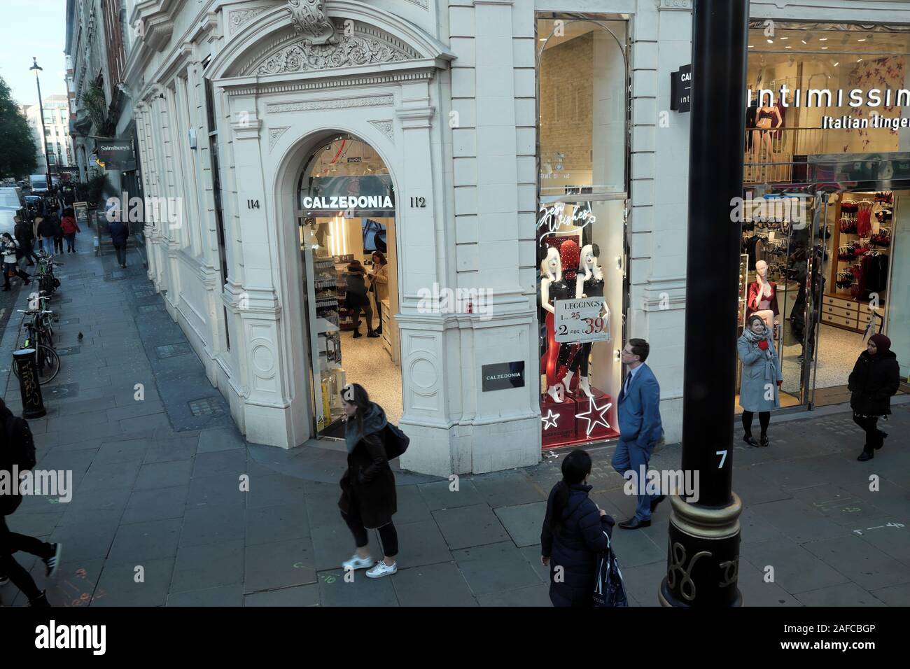 People shopping su Oxford Street in inverno a piedi passato Caldezonia ingresso del negozio nel West End di Londra Inghilterra KATHY DEWITT Foto Stock