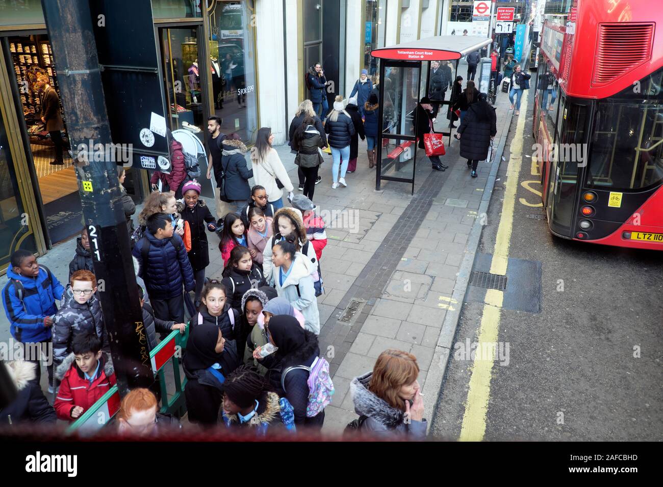 Gruppo di studenti in attesa di un autobus per una visita a Oxford Street a Londra Inghilterra Regno Unito KATHY DEWITT Foto Stock